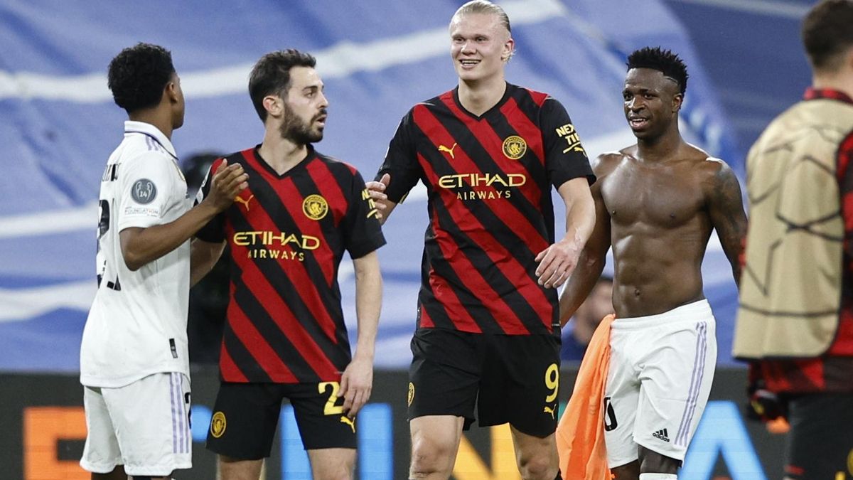 Los jugadores brasileños del Real Madrid, Vinicius Jr. (d) y Rodrygo (i), se saludan con el noruego del Manchester City, Erling Haaland y el portugués Bernardo Silva, a la finalización del encuentro correspondiente a la ida de las semifinales de la Liga de Campeones que han disputado hoy martes en el estadio Santiago Bernabéu, en Madrid.