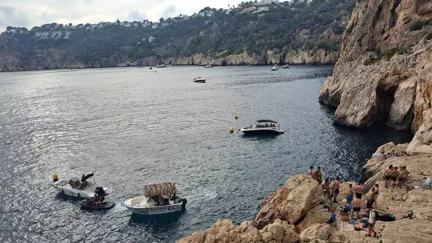 Bañistas, motos de agua, embarcaciones, mojitos... la costa más escarpada de Xàbia, conquistada por el turismo (vídeo)