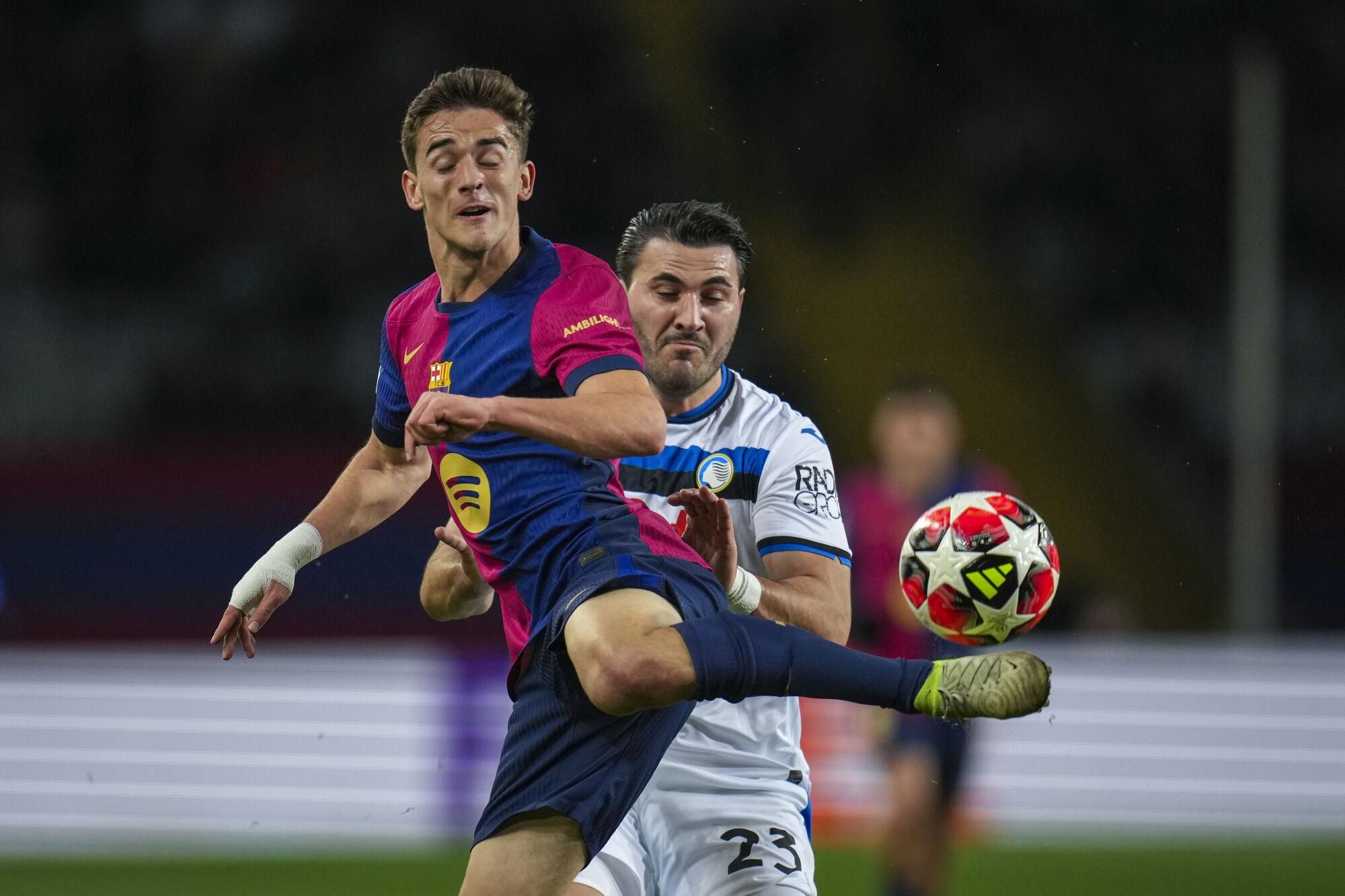 Barcelona's Gavi, left, battles for the ball with Atalanta's Sead Kolasinac during a Champions League opening phase soccer between Barcelona and Atalanta match at the Lluis Companys Olympic stadium in Barcelona, Spain, Wednesday, Jan. 29, 2025. (AP Photo/Emilio Morenatti)