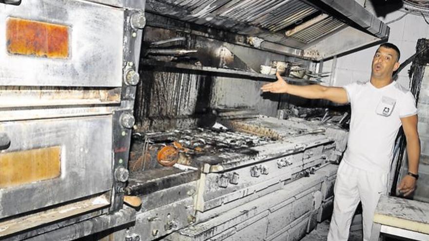 El dueño, Abdel, muestra las consecuencias del incendio en la cocina del restaurante.