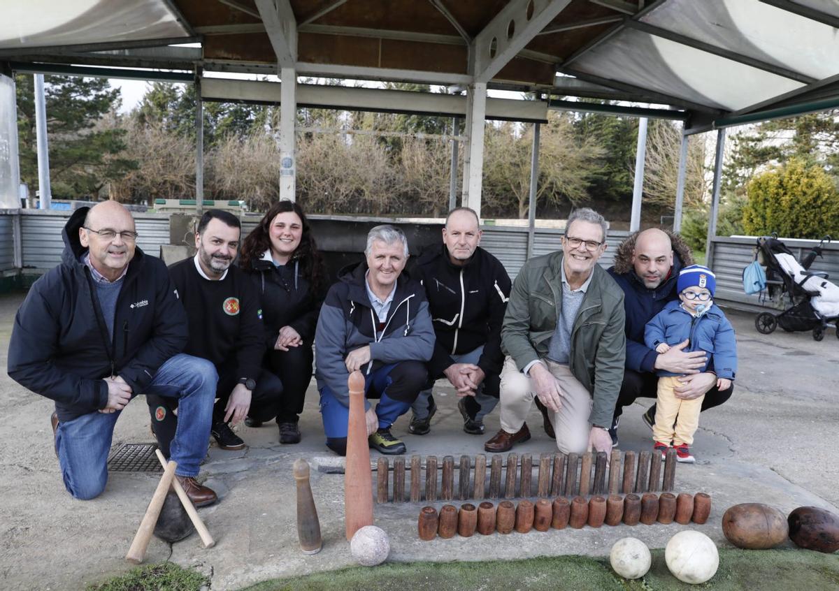 Por la izquierda, Fernando Blanco (delegado de batiente en la Federación Asturiana), Antonio González (jugador de cuatreada), Susana Barrero (bolo celta), los representantes de bolo vaqueiro Antonio Martínez, Tino Fernández y José Alonso Pisco y el representante de bolo celta Daniel Rodríguez, con el pequeño Luca, posando ayer con bolos y bolas de las distintas modalidades federadas, en La Morgal.    | FERNANDO RODRÍGUEZ