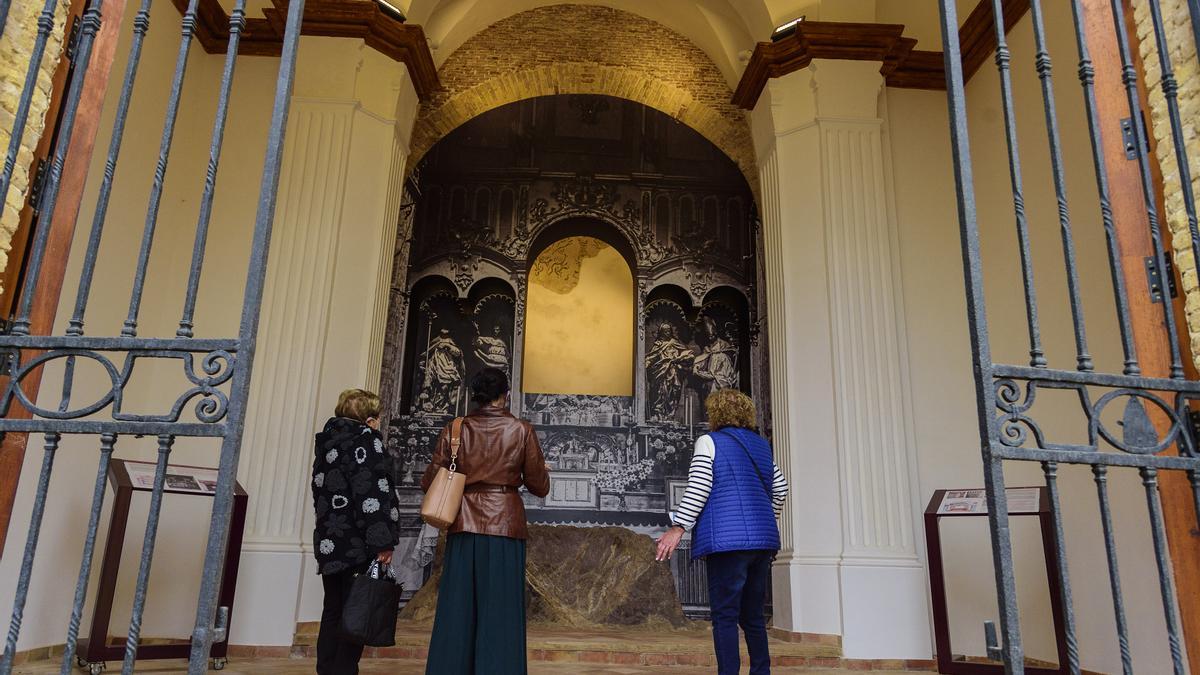 Tres visitantes observan la restaurada Capilla del Concejo.