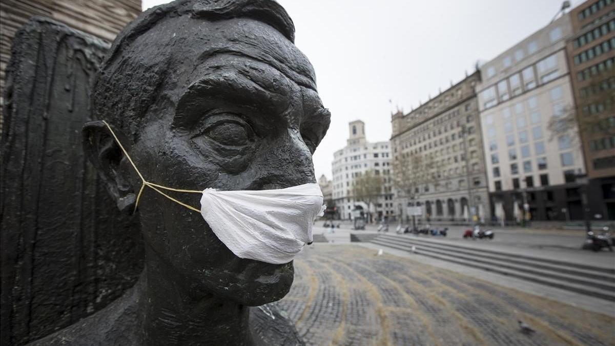 Estatua de Francesc Macià en la plaza de Catalunya con una mascarilla por el coronavirus