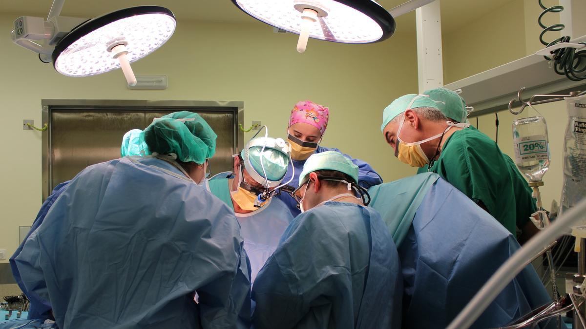 Varios médicos operan en un quirófano.