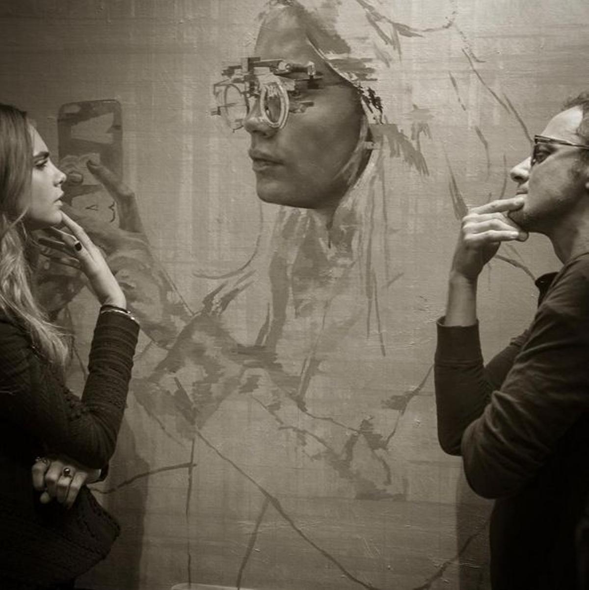 Cara Delevingne y Jonathan Yeo admirando el retrato de Cara