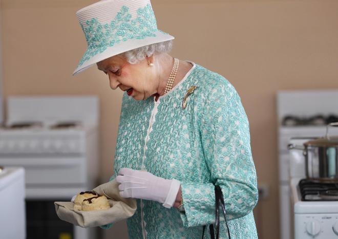 La reina Isabel II probando unos bollos durante un viaje a Australia en 2011