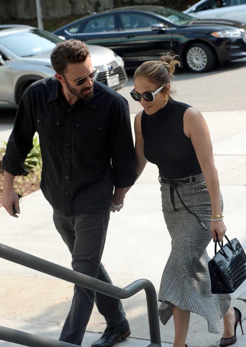 Jennifer Lopez y Ben Affleck, de la mano; ella, con falda midi príncipe de gales de Tom Ford