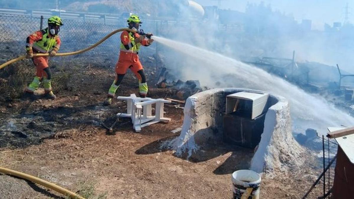 Dos bomberos, en plena extinción.
