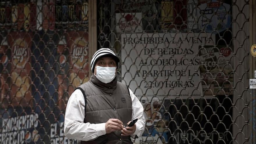 Un hombre camina frente a una tienda cerrada.