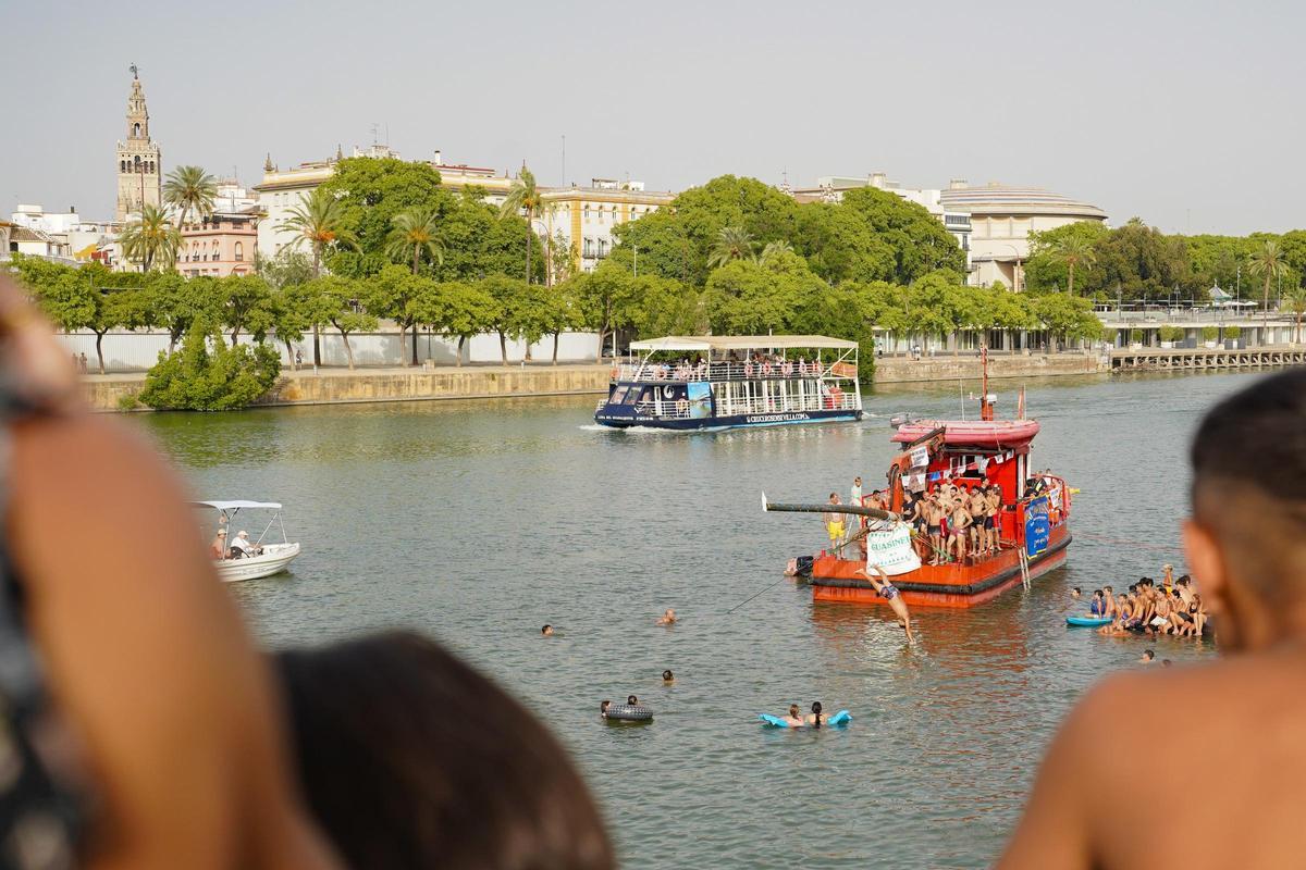 La 'cucaña', el juego centenario que regresa cada verano al río Guadalquivir por la Velá de Santa Ana en imágenes