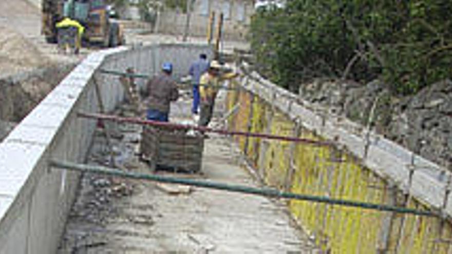 Tres obreros trabajan en la adecuación del arroyo.