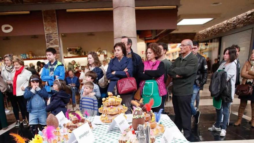 Asistentes, ayer, en el centro comercial de Trasona, ante varios de los bollos que se presentaron al concurso.