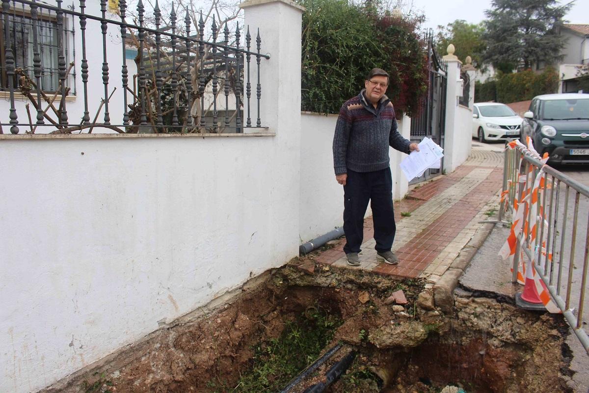 El vecino de Cabra Antonio Alcalá Sabariego junto al socavón que hay a la puerta de su casa desde hace tres meses