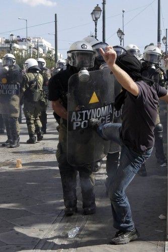 Demonstrator kicks riot police at a protest march by Greece's Communist party in central Athens during a 24-hour labour strike