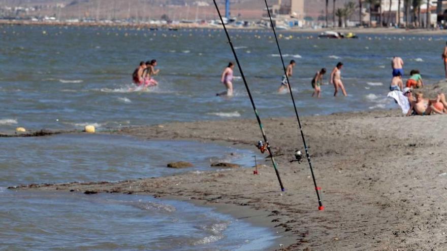 Bañistas y cañas de pesca, en el Mar Menor