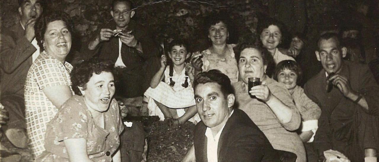 Un grupo de amigos disfrutan de una comida en el campo de la fiesta de Reboreda en los años sesenta.