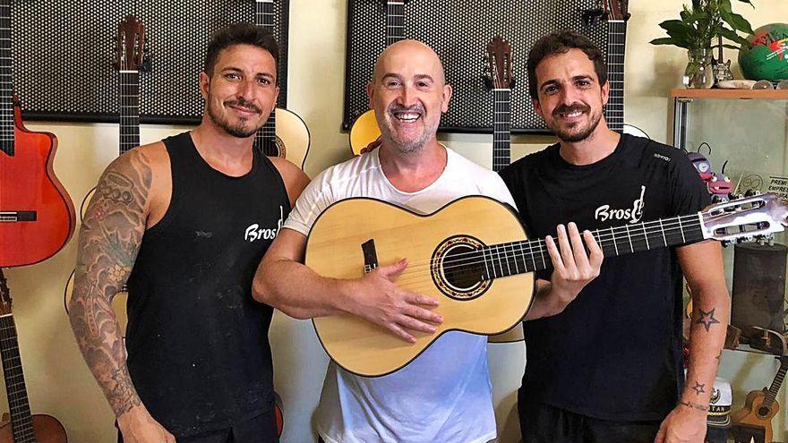 El actor muestra su guitarra flanqueado por los hermanos Broseta.