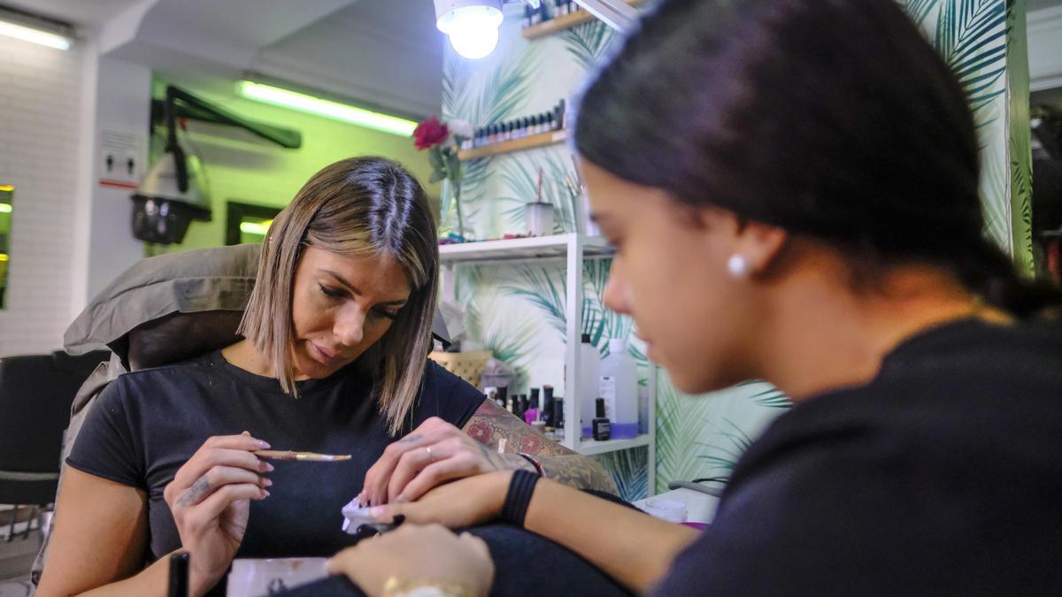Una trabajadora atiende a una clienta en un centro de estética.