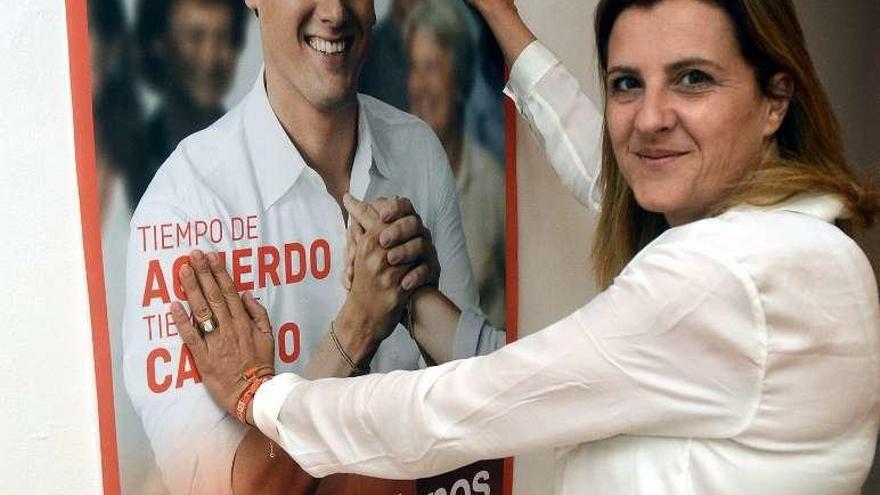 María Rey, junto a un cartel electoral de Rivera. // Rafa Vázquez