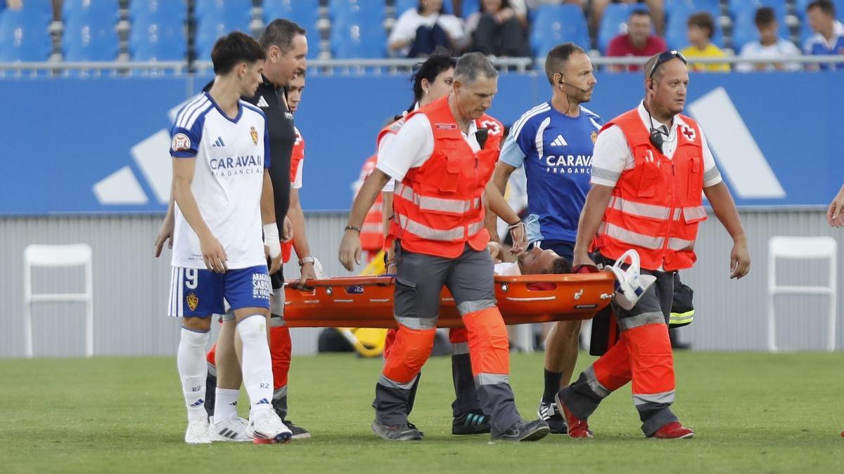 Diego González, siendo retirado en camilla ante el interés de Pau Sans, tras su golpe en la cabeza contra el Bilbao Athletic.