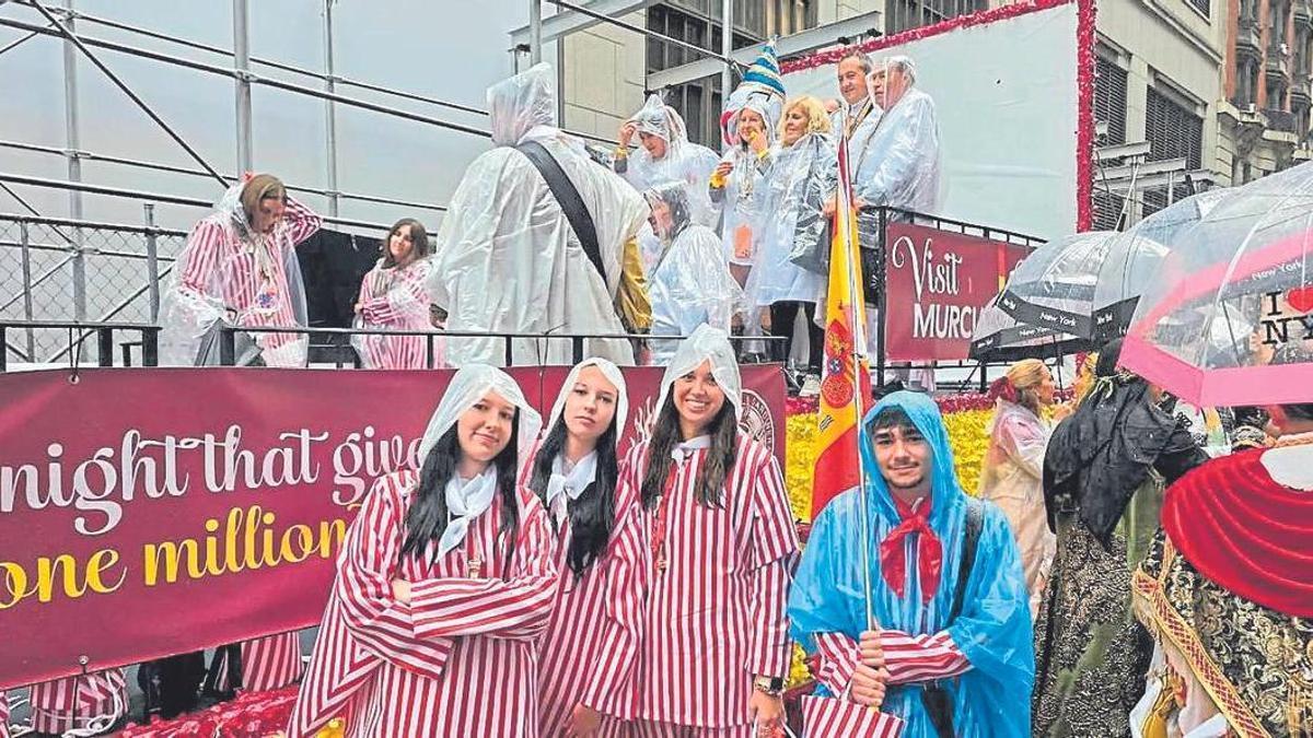 Sardineros con chubasquero por la lluvia junto a la carroza exclusiva del desfile que animaba a visitar Murcia.