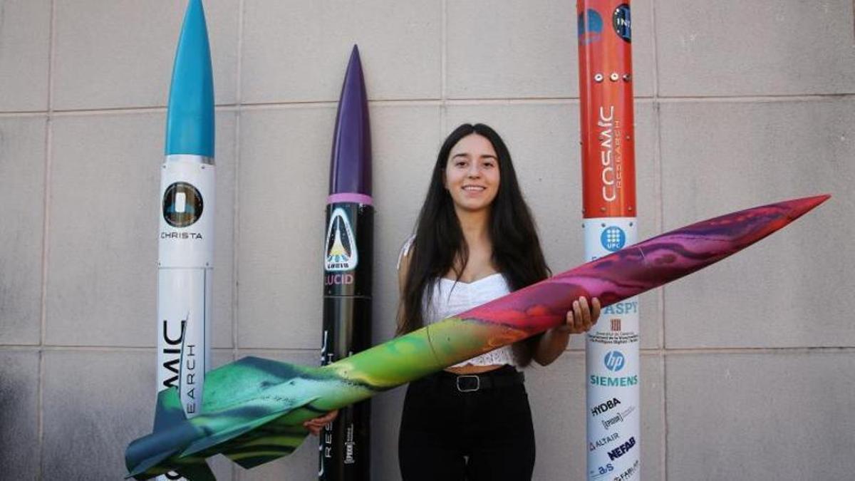 La ingeniera Alba Badia posa junto a varios prototipos de cohete desarrollados por la plataforma Cosmic Research.