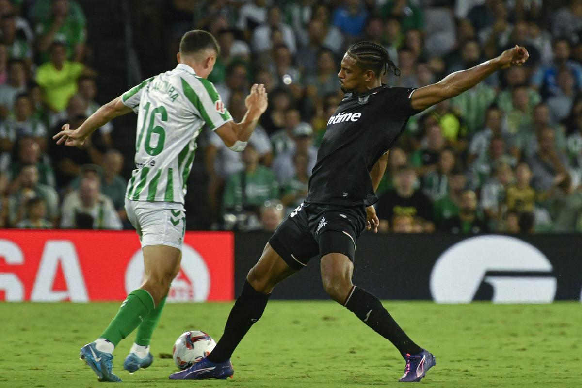 El centrocampista del Real Betis Sergi Altimira disputa un balón con el francés Sébastien Haller, del CD Leganés, durante el encuentro de la quinta jornada de LaLiga EA Sports que Real Betis y CD Leganés disputan este viernes en el estadio Benito Villamarín de Sevilla.