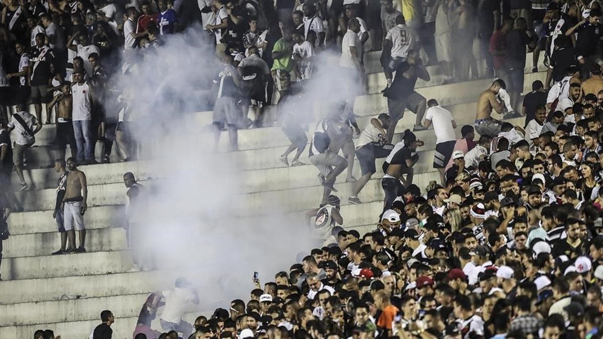 Los aficionados de Vasco da Gama se enfrentan con la policía durante el partido de su equipo contra el Flamengo.