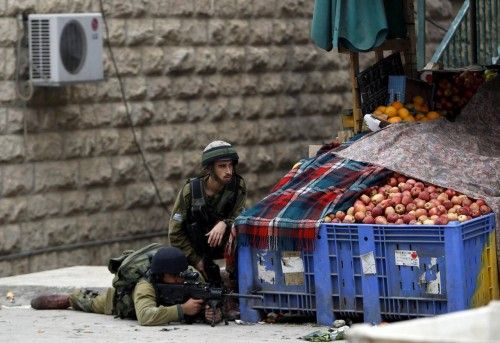 Israeli soldiers take position during clashes with stone-throwing Palestinians in Hebron