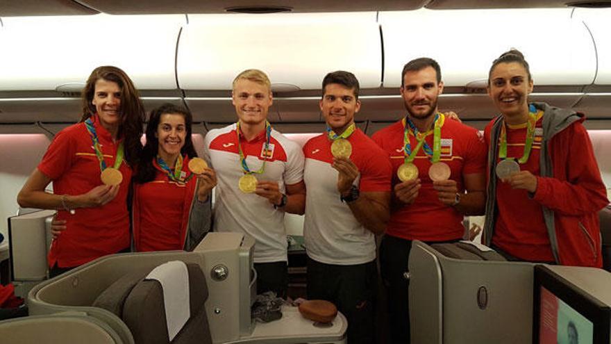 Marcus Cooper, tercero por la izquierda, y Alba Torrens, a la derecha, con otros medallistas antes de embarcar.