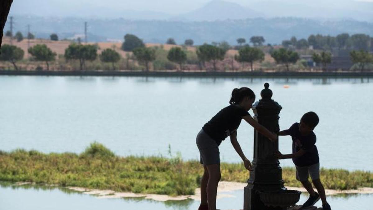 Dos nens es refresquen al parc de l'Agulla de Manresa