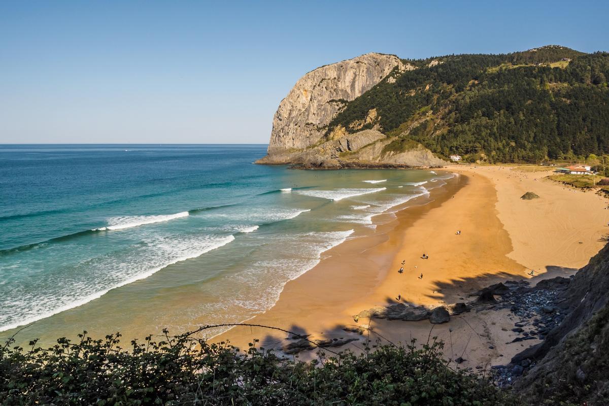 El peñón de Ogoño al fondo de la playa de Laga