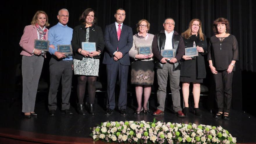 Seis de los siete profesores homenajeados, anoche en el teatro Hespérides, junto al alcalda de Guía, en el centro, y la concejal.