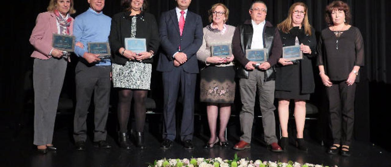 Seis de los siete profesores homenajeados, anoche en el teatro Hespérides, junto al alcalda de Guía, en el centro, y la concejal.