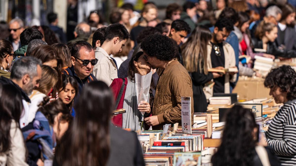 Una pareja se besa mientras miran libros. Ambiente en Paseo de Gracia de Barcelona en el dia de Sant Jordi. FOTO de ZOWY VOETEN