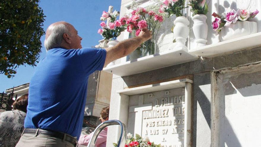 Un hombre coloca flores ante una tumba en el cementerio de San Miguel, en una imagen de 2013.