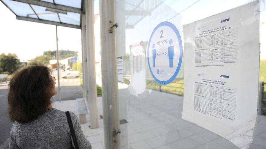 Una mujer contempla los horarios de las líneas de Monbus en una parada de Silleda. |   // BERNABÉ/JAVIER LALÍN