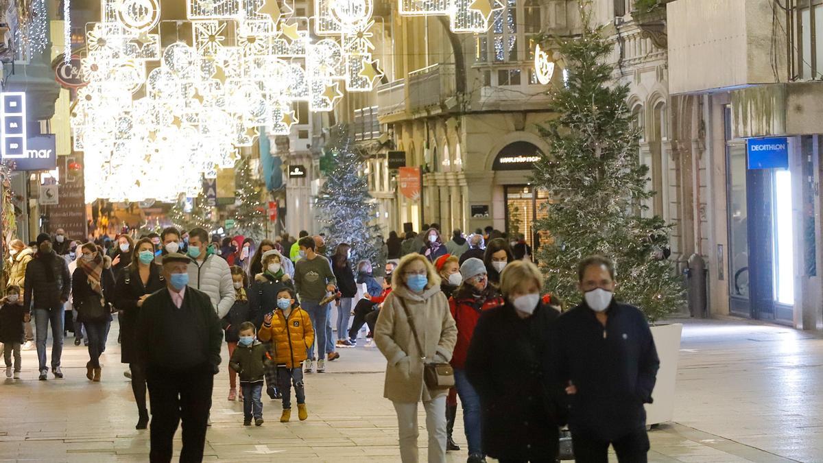 Varias personas con mascarilla caminan por una calle de Vigo.