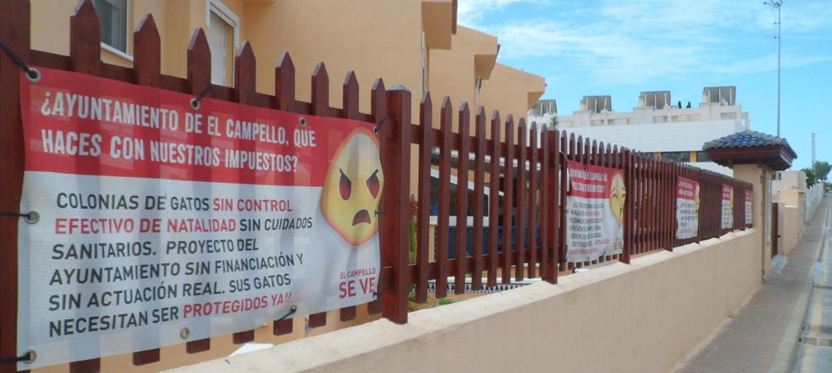 Una urbanización denuncia la falta de servicios en la zona de La Illeta colgando carteles en sus muros
