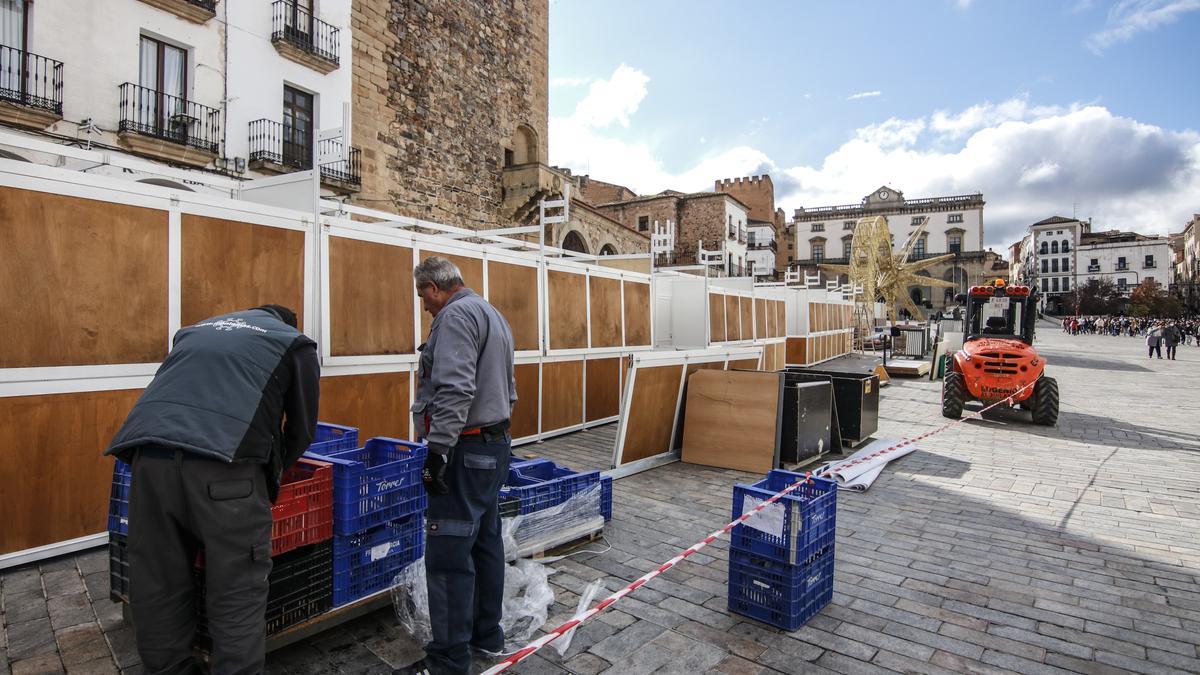 Operarios ultiman el montaje del mercado navideño en la plaza, este martes.