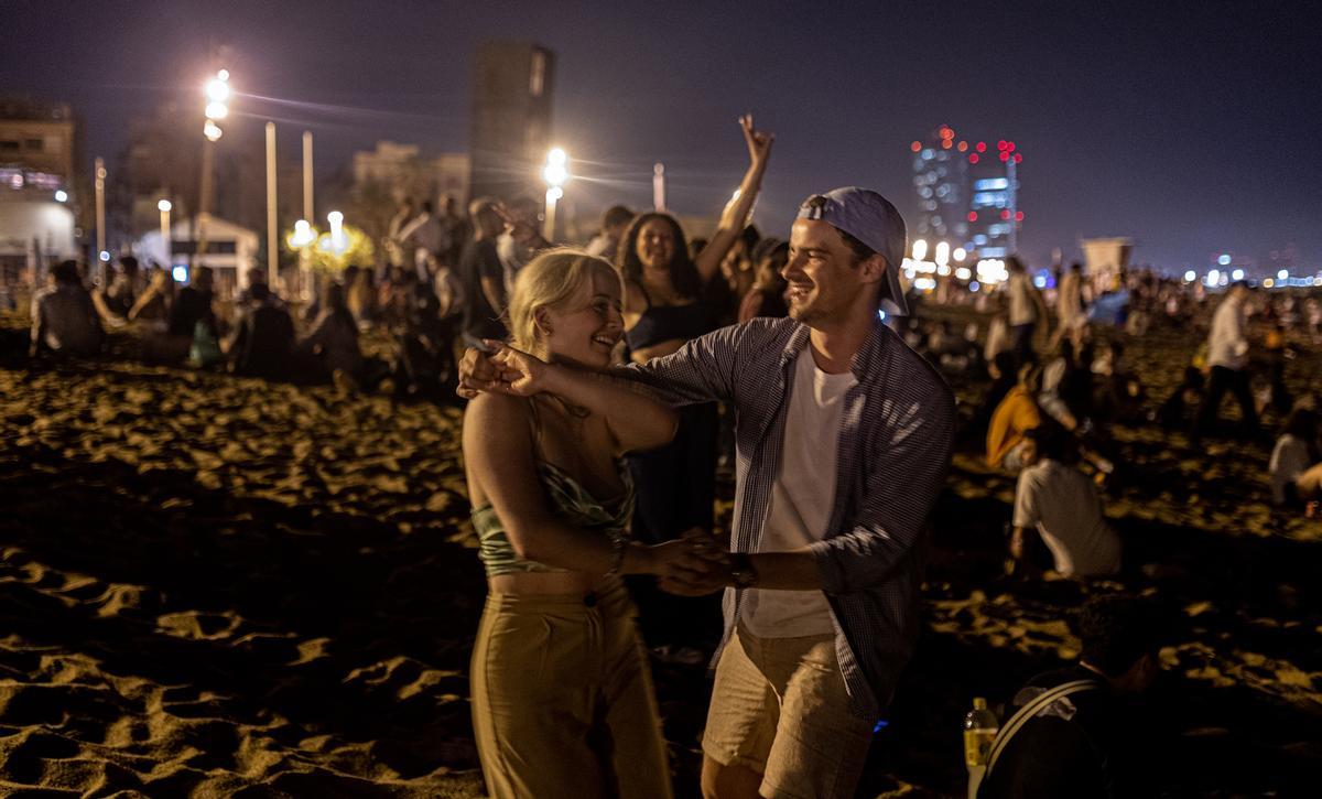 Dos jóvenes bailan en la Barceloneta a principios de julio, antes de la vuelta del toque de queda.