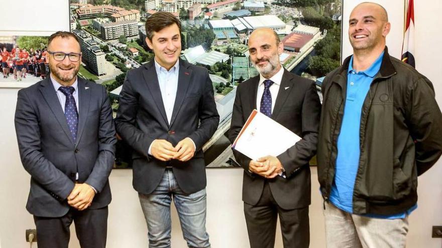 De izquierda a derecha, Jorge Morán, José María Pérez, Antonio Corripio y José Ramón García, delante de una imagen de las instalaciones grupistas.