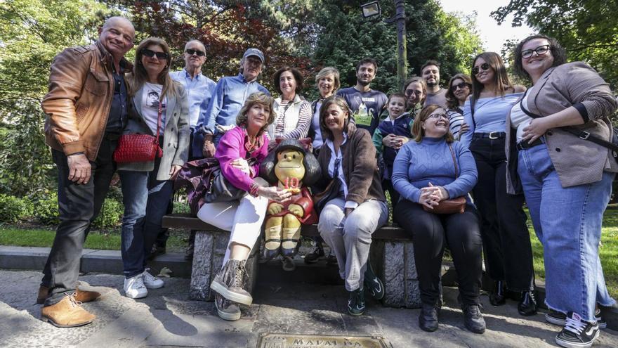 Turistas de distintos puntos del país posan con la estatua de Mafalda, con un carbayón y las velas por el cumpleaños de la escultura.