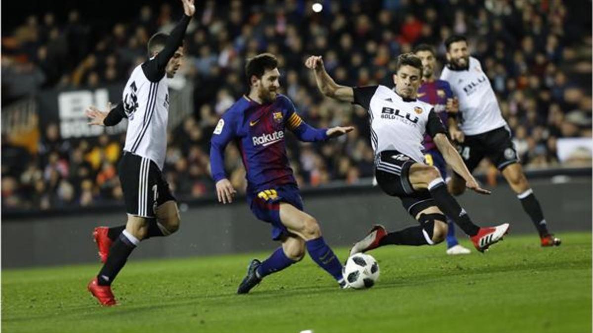 Messi controla un balón entre Gayá (izquierda) y Gabriel Paulista.