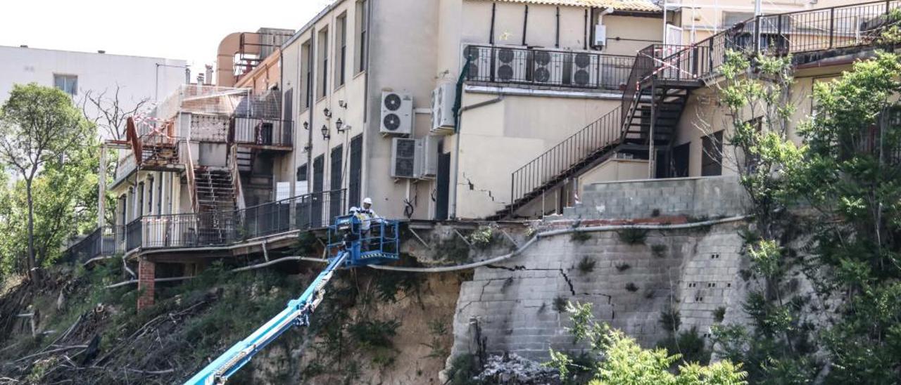 Operarios trabajando en lo alto de un elevador en el lugar en el que se produjo el desprendimiento, justo debajo de los locales de las filaes.