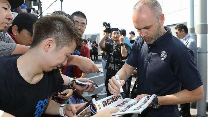 Andrés Iniesta firma autógrafos a aficionados del Kobe, el equipo en el que milita en Japón. // AFP