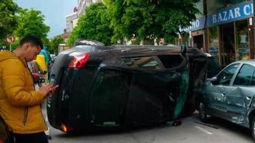 Espectacular vuelco de un coche en la avenida de la Argentina, en Gijón, sin daños graves