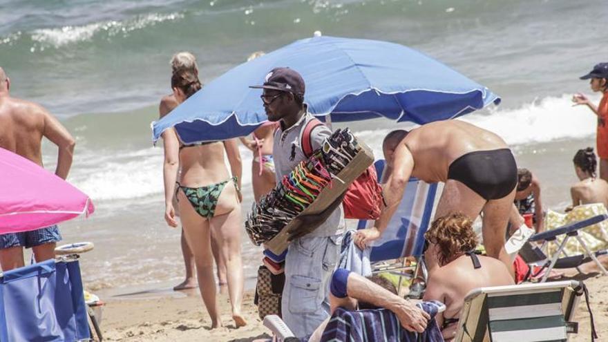 Venta de gafas de sol y otros artículos en una playa de Torrevieja.