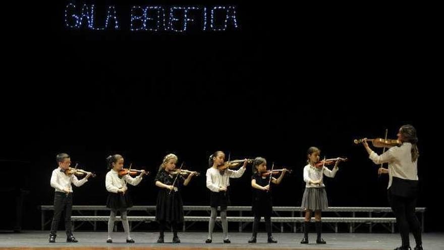 Un grupo de niños toca el violín durante la gala.