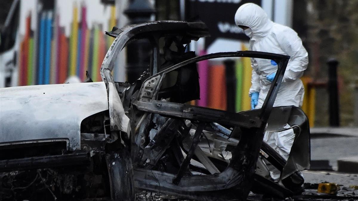 Un forense inspecciona la zona donde ha explotado el coche bomba en Londonderry,